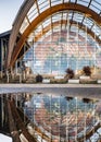 Sheffield Winter Gardens green house arches reflected mirror image in water symmetrical wooden building. Parabolic arch.