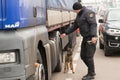 SHEGINI, UKRAINE - NOVEMBER, 2018: Ukrainian border guard with a service dog inspects vehicles at the checkpoint at the Ukrainian-