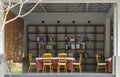 Shelf with boxes and books. Wooden table and wooden chairs in open view relaxing room