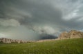 A shelf cloud accompanies this thunderstorm as it approaches a rocky hillside. Royalty Free Stock Photo