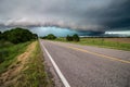 A shelf cloud and severe storm filled with rain and hail approach a highway. Royalty Free Stock Photo