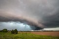 A shelf cloud and severe storm filled with rain and hail over a farm field. Royalty Free Stock Photo