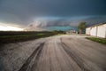 A shelf cloud and storm approach old farm buildings at sunset. Royalty Free Stock Photo