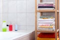 Shelf with colorful towels in the bathroom and hygiene products in the background Royalty Free Stock Photo