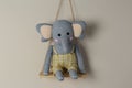 Shelf with cute toy elephant on beige wall. Royalty Free Stock Photo