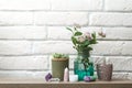 A shelf for decorative ornaments. Home-made beautiful things. Crystals, candlesticks, flowers in a jar against a white brick wall