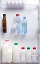 On the shelf in the door of the white refrigerator, dairy products, kefir, cream and water