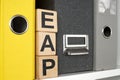 Shelf with folders and cubes with letters. EAP Employee Assistance Program.