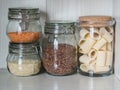 Shelf in the kitchen with various jars of cereals. Glass jars with pasta, lentils and quinoa.