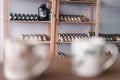 shelf with neat and tidy glass jars containing concentrated milk next to the wall behind the table with porcelain cups