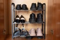 A shelf with shoes in the closet, sneakers, sneakers and shoes are on the shelf in the hallway, women's worn shoes