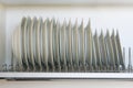 Shelf for tableware drying in modern kitchen. White glass and ceramic dishes on metal rack inside kitchen cupboard Royalty Free Stock Photo