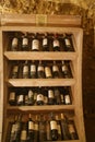 Shelf in wine cellar with old and dusty wine bottles