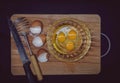 Shell of chicken eggs, whisk for whipping, knife, in a glass bowl are chicken eggs with yolk. Making an omelet