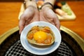 A shell crab of kani miso topped with fresh salmon and yolk egg.