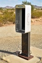 Empty telephone booth in desert outdated technology