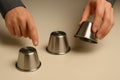 Shell game in action with metal cups. hands involved in the classic game of chance and skill, a test of observation and luck Royalty Free Stock Photo