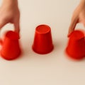 A shell game in motion. The three-cup game, where a small object is hidden under one of three cups and quickly shuffled Royalty Free Stock Photo