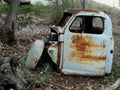 A shell of an old rusted blue motor vehicle