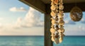 Shell wind chimes hang from a wooden structure, featuring various white and brown Royalty Free Stock Photo