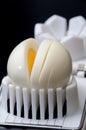 Shelled boiled egg on a white chopper and black background Royalty Free Stock Photo