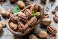 Shelled and cracked pecan nuts in the wooden bowl on wooden table. Top view Royalty Free Stock Photo