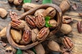 Shelled and cracked pecan nuts in the wooden bowl on wooden table. Top view Royalty Free Stock Photo