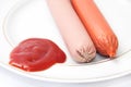 Shelled frankfurters on a plate with ketchup