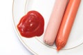 Shelled frankfurters on a plate with ketchup