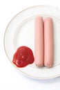 Shelled frankfurters on a plate with ketchup