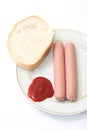 Shelled frankfurters on a plate with ketchup and bread