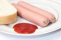 Shelled frankfurters on a plate with ketchup and bread