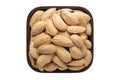 Shelled paper almonds nuts in square bowl isolated on white background. organic food, top view Royalty Free Stock Photo