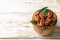 Shelled pecan nuts in bowl on wooden table Royalty Free Stock Photo