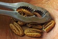 SHELLED PECAN NUTS AND NUT CRACKER IN A WOODEN BOWL Royalty Free Stock Photo