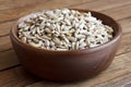 Shelled sunflower seeds in wood bowl on rustic table. Royalty Free Stock Photo