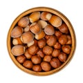 Shelled and unshelled hazelnuts in a wooden bowl