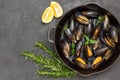 Shellfish Mussels in frying pan. Rosemary and lemon on table. Shellfish seafood