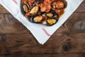 Shellfish seafood. Hot fresh italian appetizing steamed mussels in tomato sauce with olives and red pepper on vintage wooden table