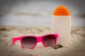 Shells, pink sunglasses and sun lotion at beach, concept of summer time Royalty Free Stock Photo