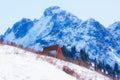 Shelter against the backdrop of a harsh snowy mountain in winter. Nursultan Peak, former name Komsomol with glacier over mountain