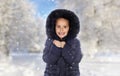 Sheltered girl with black coat in a cold and snowed day