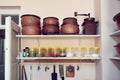 Shelves of an antique rural kitchen with vintage earthenware pots, coffee grinder and jars