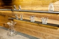 Shelves with collection of decorative glasses on wooden wall background Royalty Free Stock Photo