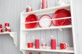 Shelves with dishes. Interior light grey kitchen and red christmas decor. Preparing lunch at home on the kitchen concept Royalty Free Stock Photo