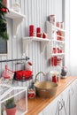 Shelves with dishes. Interior light grey kitchen and red christmas decor. Preparing lunch at home on the kitchen concept Royalty Free Stock Photo