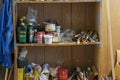 Shelves with paint buckets, brushes, turpentine, benzine and various stuff