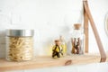 Shelves with spices and pasta in jars on white brick wall in kitchen