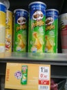 Shelves in supermarket with jars of potato chips, colors green, yellow, blue, white