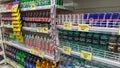 Shelves with variety refreshing of beverage for sale. Soda pop cans and plastic bottles in vertical freezer at supermarket